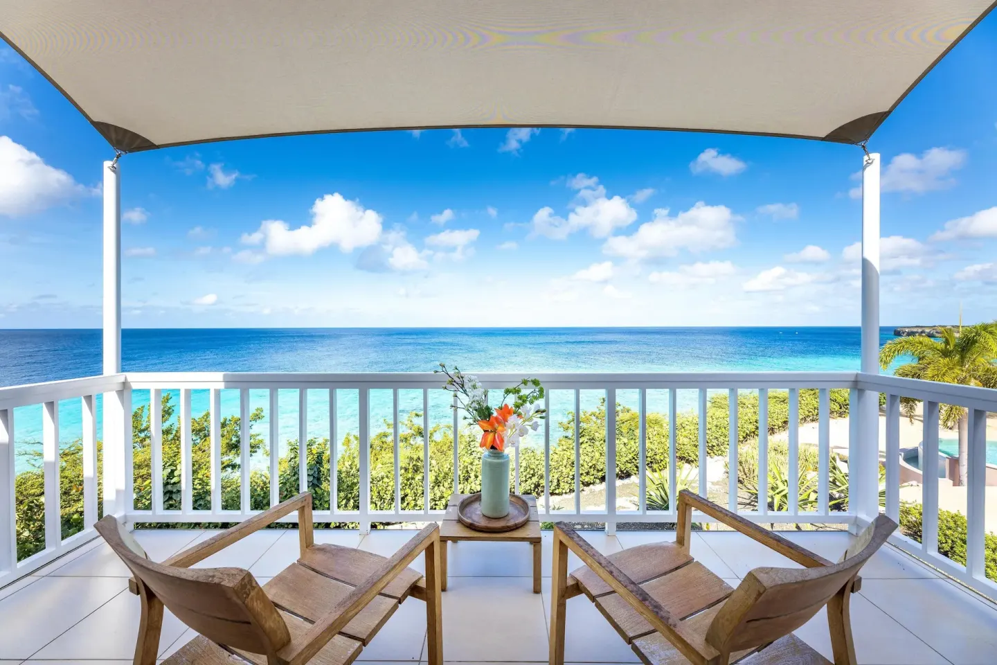 Superior Oceanfront balcony with two chairs and wide sea view at Coral Estate Luxury Resort.