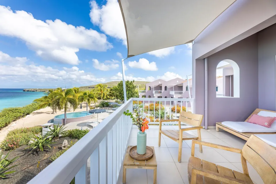 Superior Oceanfront terrace overlooking palms and pool at Coral Estate Luxury Resort.
