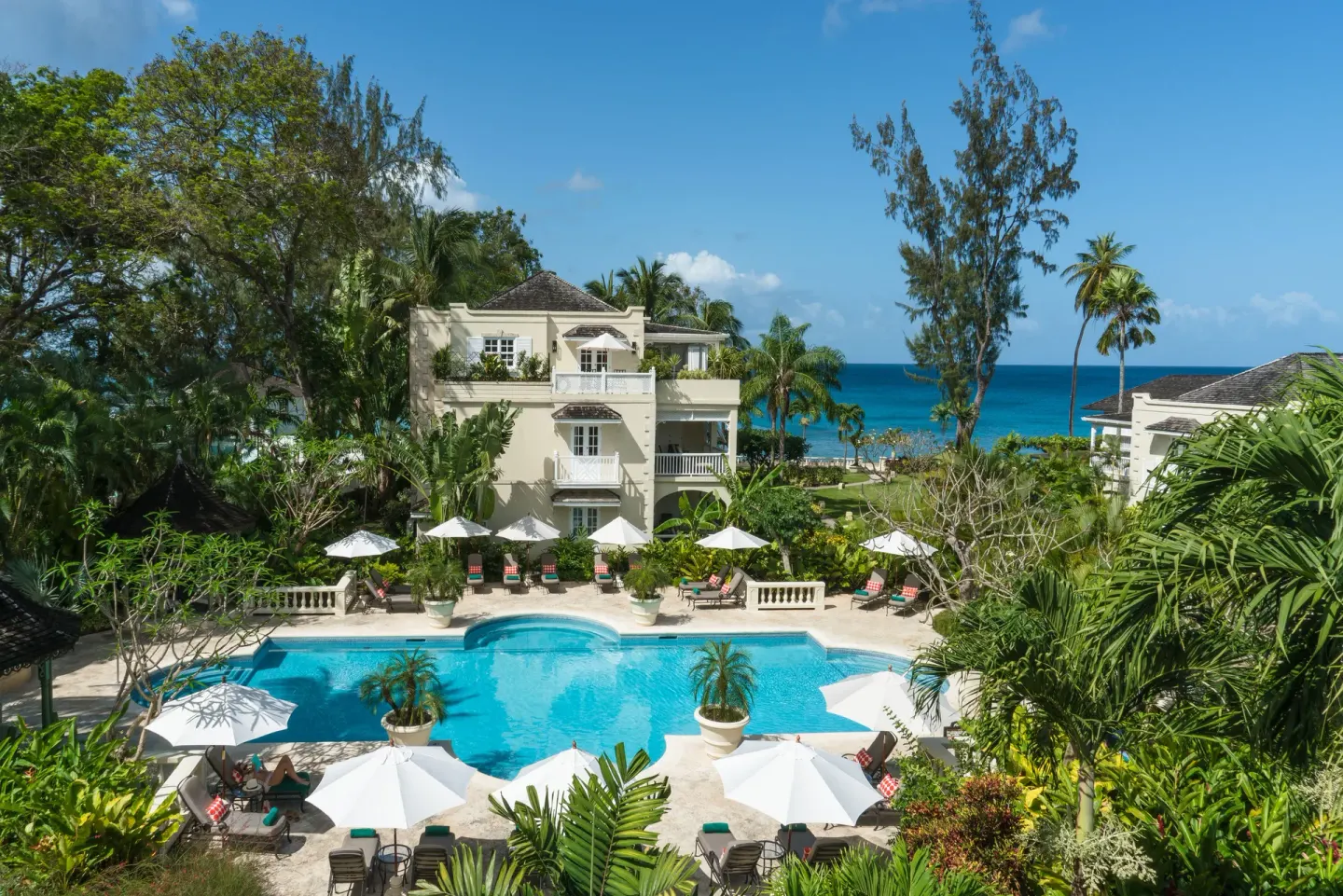 Elevated view of the pool, gardens, buildings, and sea at Coral Reef Club.