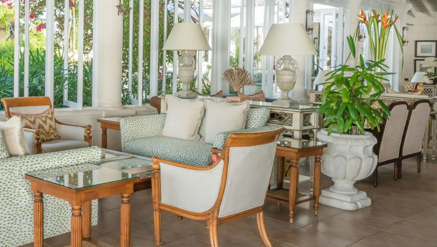Patterned sofas, armchairs, and tropical plants in a lounge at Coral Reef Club.