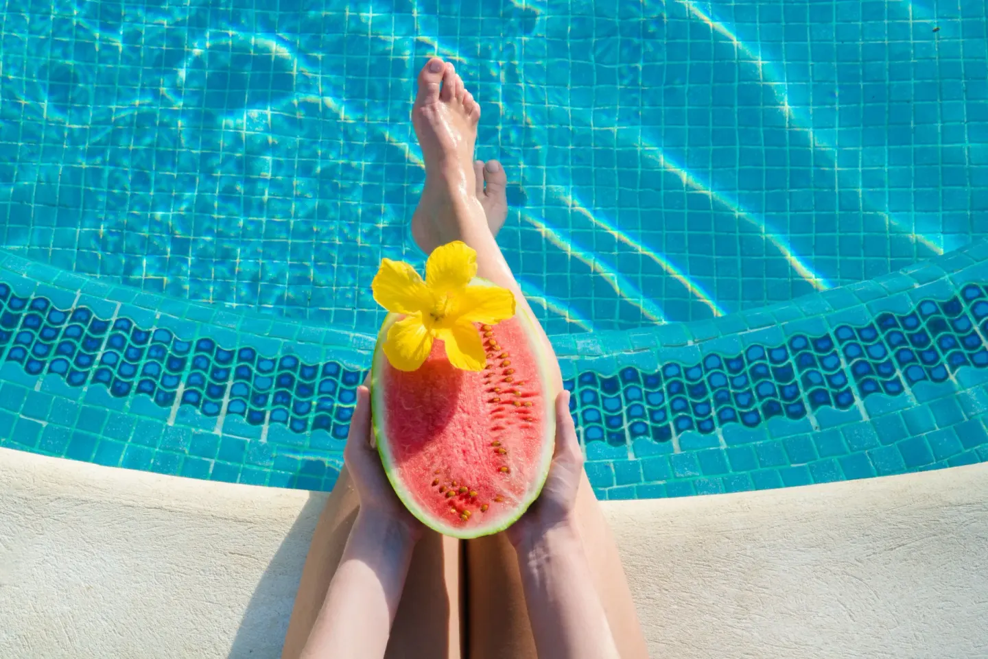 Watermelon with a flower is held beside the tiled pool at Coral Reef Club.