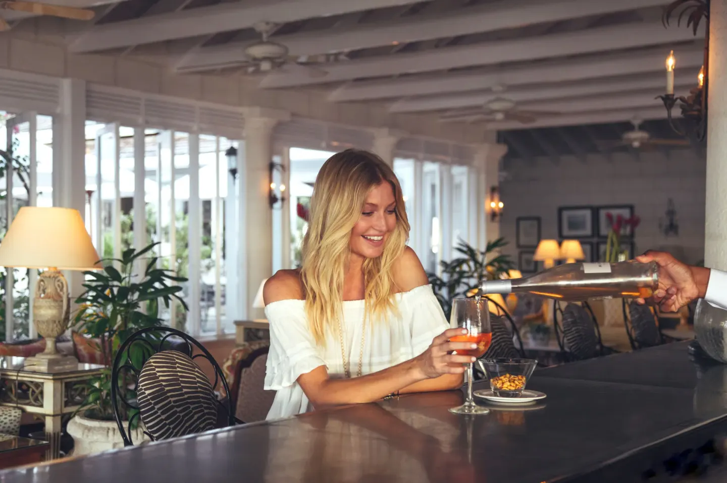 Guest being served a drink at the bar at Coral Reef Club.