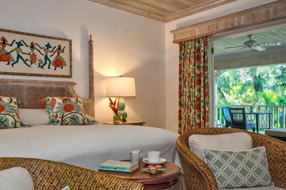 Cottage guest room with king bed and garden-facing balcony at Coral Reef Club.