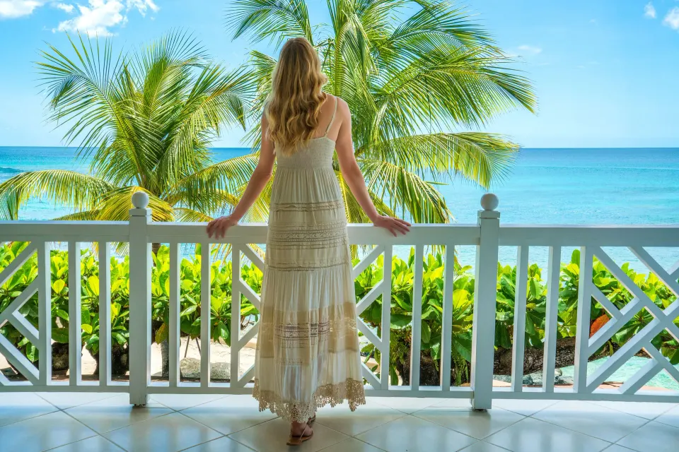 Junior Suite balcony with a woman facing the sea at Coral Reef Club.