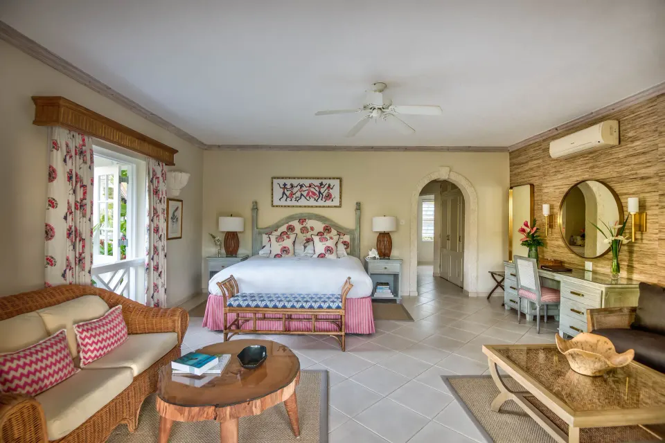 Junior Suite with bed, wicker sofa and vanity area at Coral Reef Club.