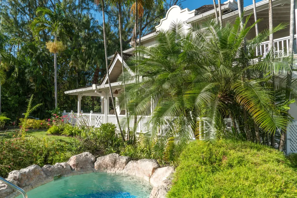 Luxury Cottage exterior with lush gardens and small plunge pool at Coral Reef Club.