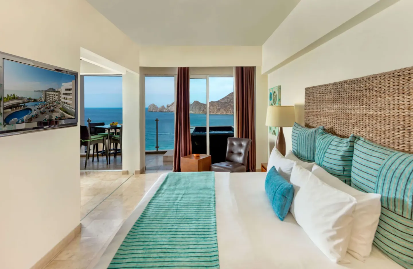 Guest room king bed with turquoise bedding and ocean-view balcony at Corazón Cabo.