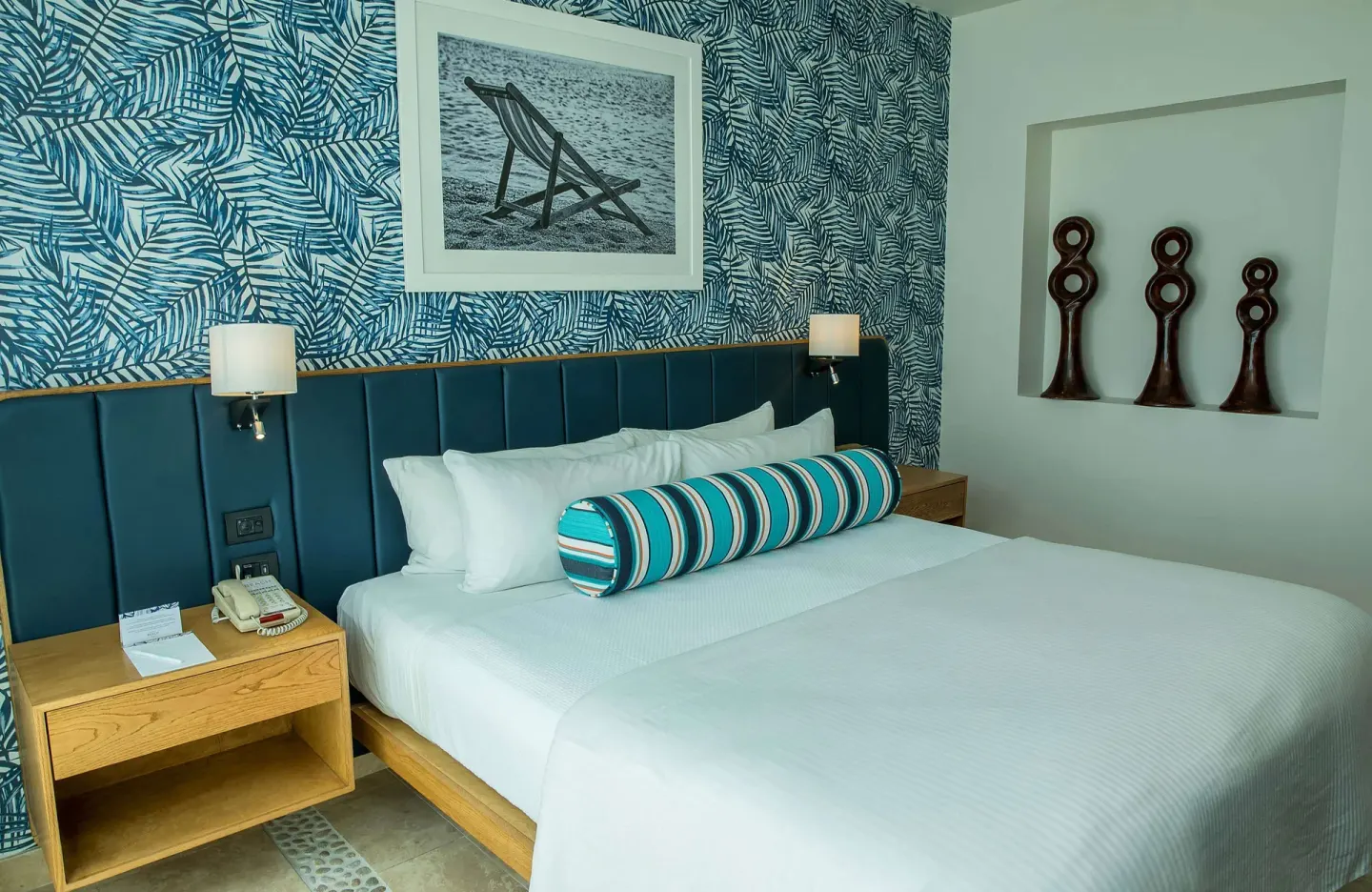 King bed with teal headboard and tropical leaf wallpaper at Corazón Cabo.