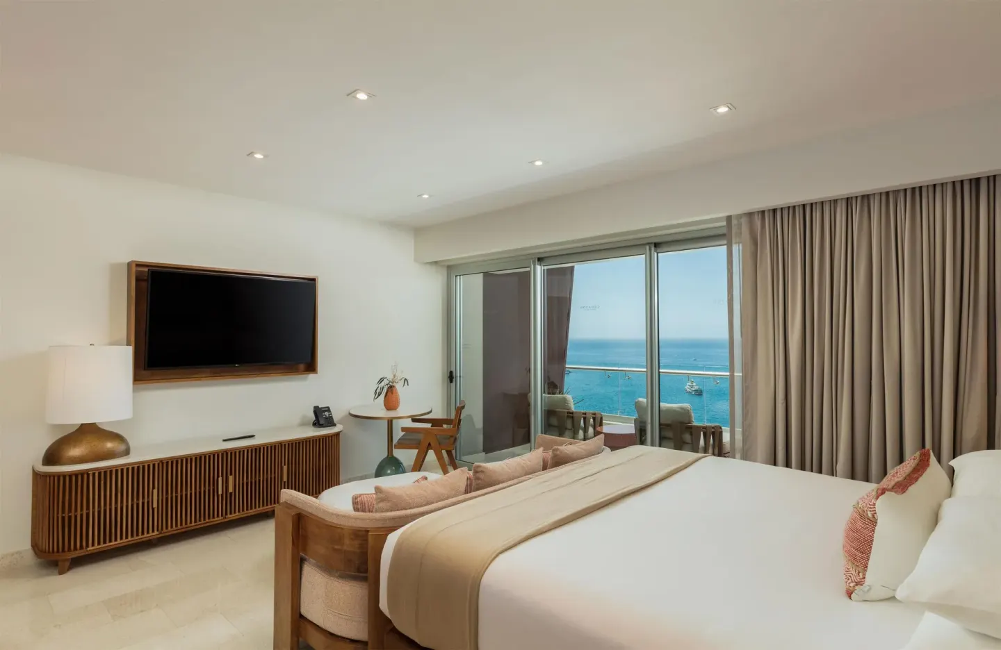 King-bed guest room with balcony and blue ocean view at Corazón Cabo.