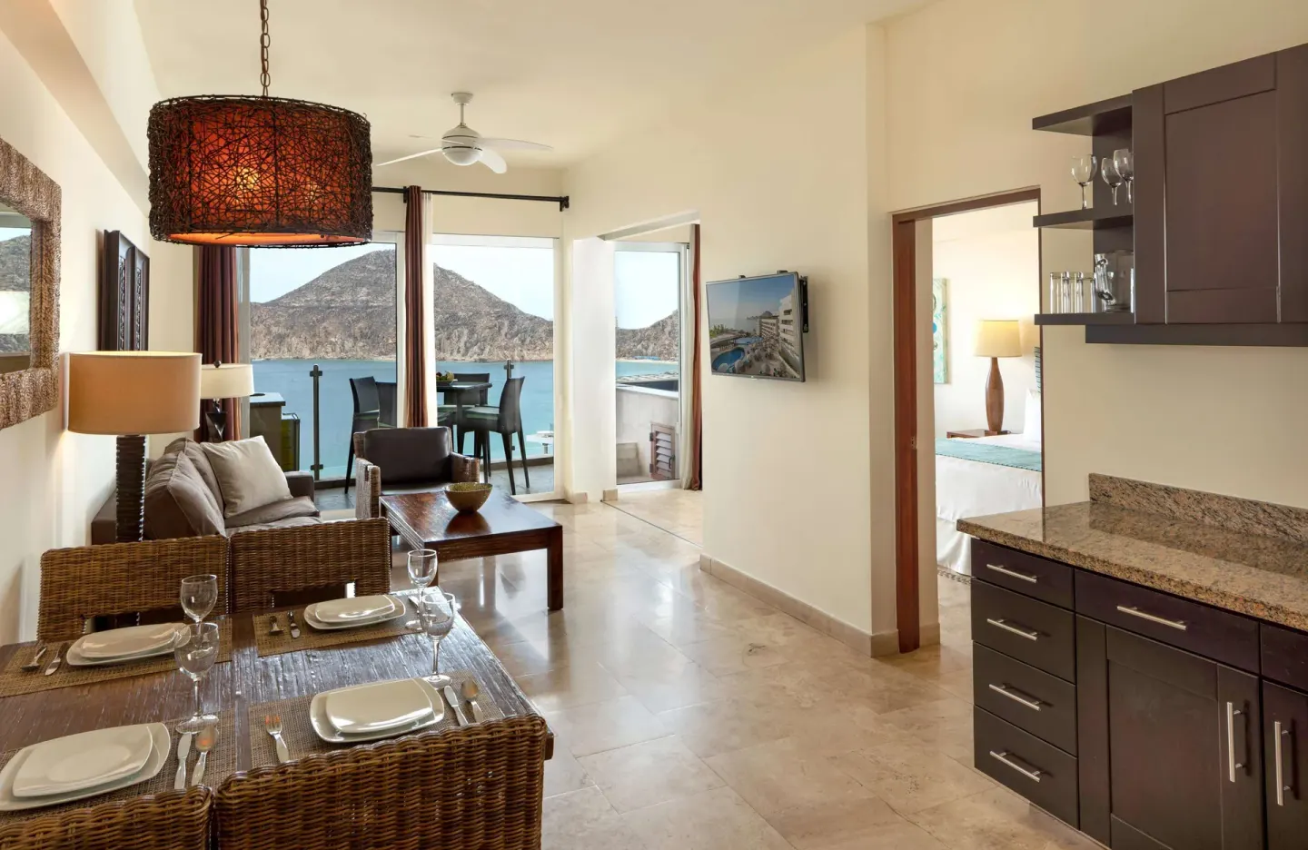 Suite living and dining area with kitchenette and ocean-view balcony at Corazón Cabo.