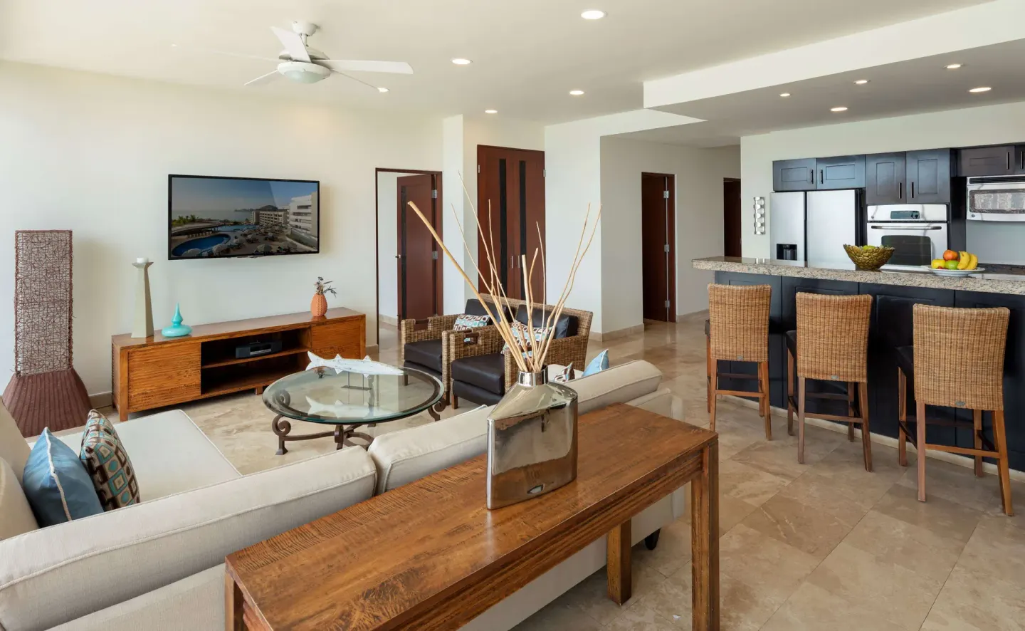 Suite living room with sofas, kitchen island, and bar seating at Corazón Cabo.