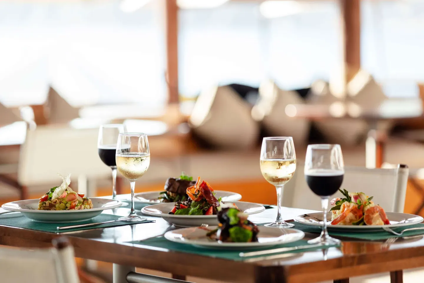 Plated dishes and wine glasses on a restaurant table at Corazón Cabo.