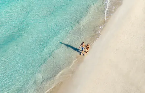 Aerial view of a couple walking along the turquoise shoreline at Couples Negril.