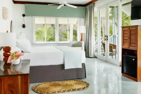 Bright guest room with king bed and balcony doors at Couples Negril.