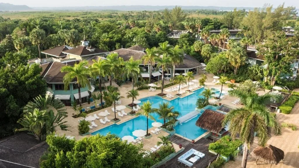 Aerial view of the main pool and palm-filled grounds at Couples Negril.