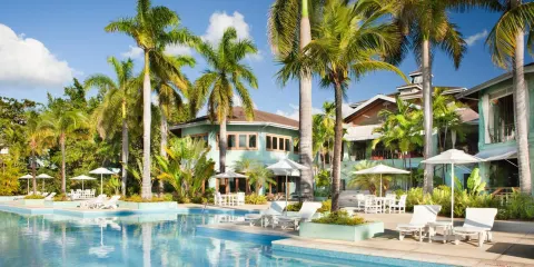Palm-lined pool with loungers and umbrellas at Couples Negril.