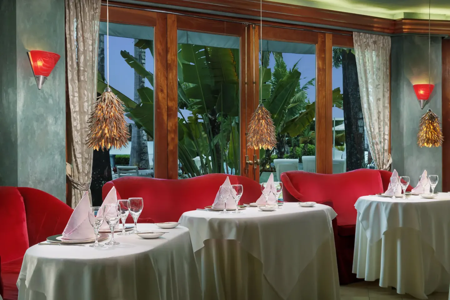 Elegant dining room with red sofas and white table settings at Couples Negril.