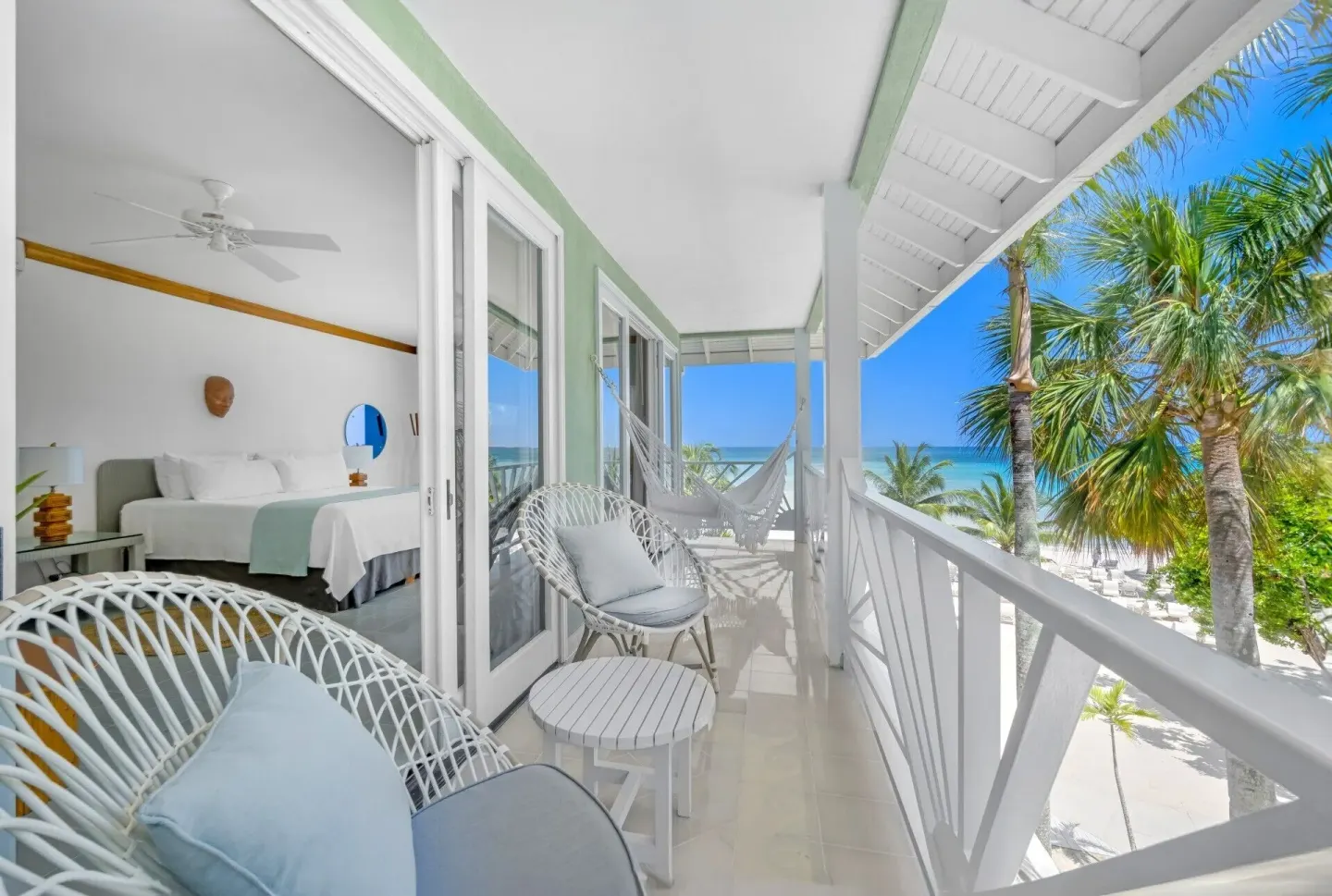 Beachfront Suite balcony with seating, hammock, ocean view, and bedroom doorway at Couples Negril.