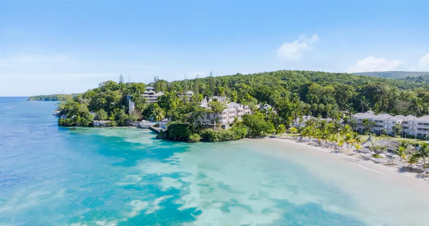 Aerial view of the beach, turquoise water, and resort buildings at Couples Sans Souci.