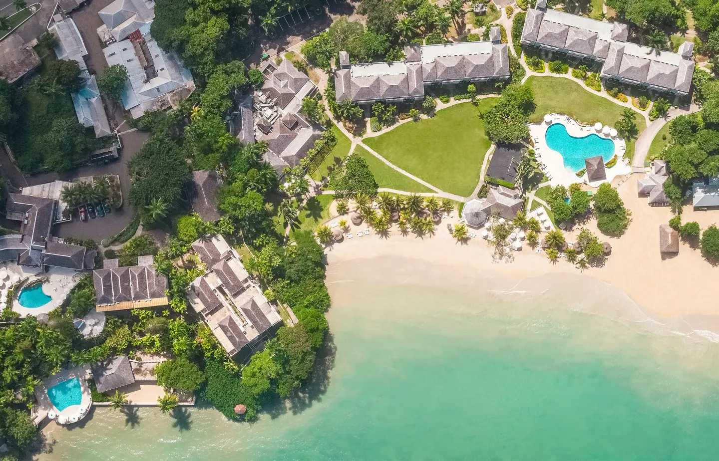 Aerial view of beach, pools, lawns, and resort buildings at Couples Sans Souci.