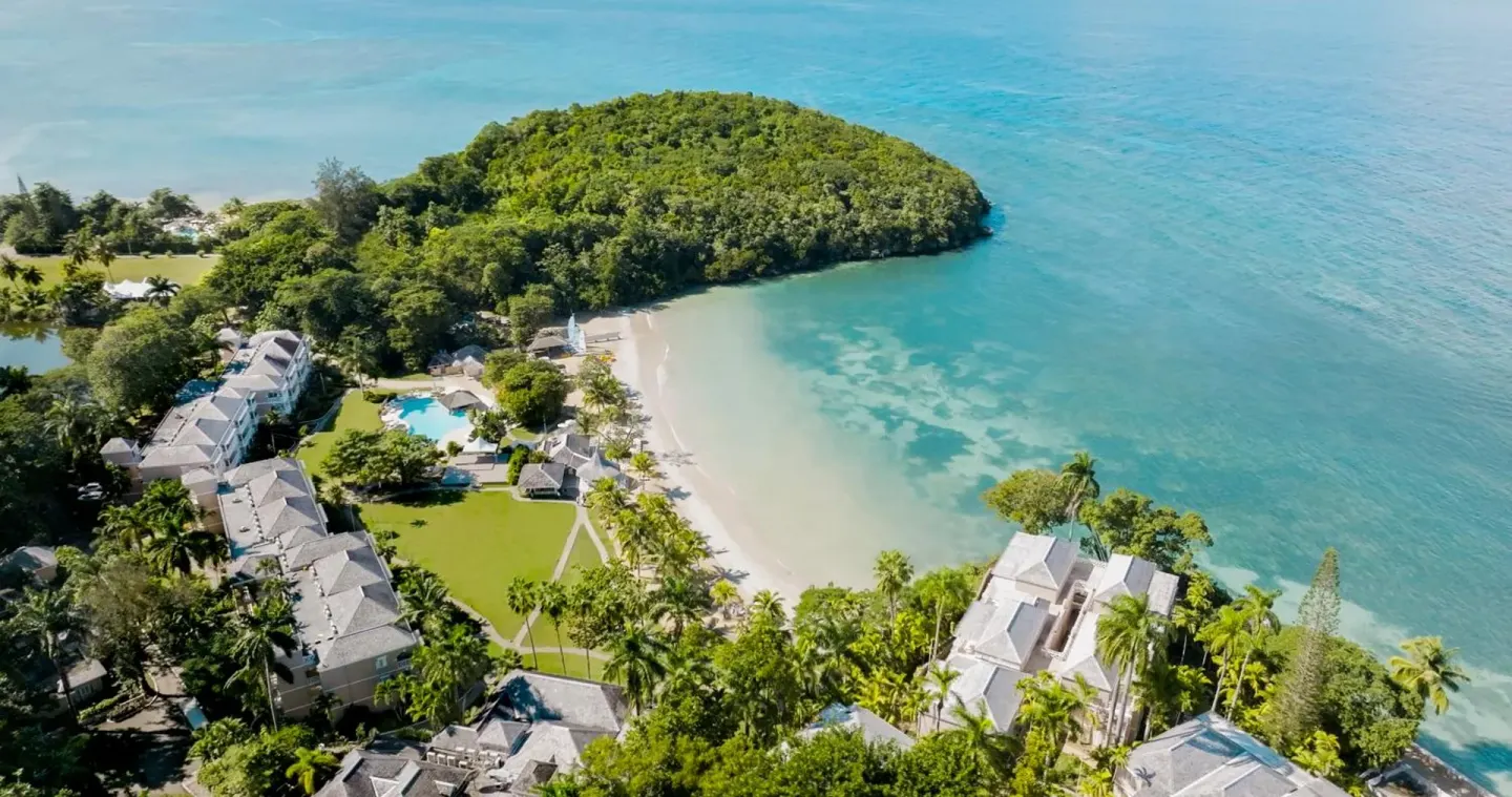 Aerial view of the cove, beach, pools, and resort grounds at Couples Sans Souci.
