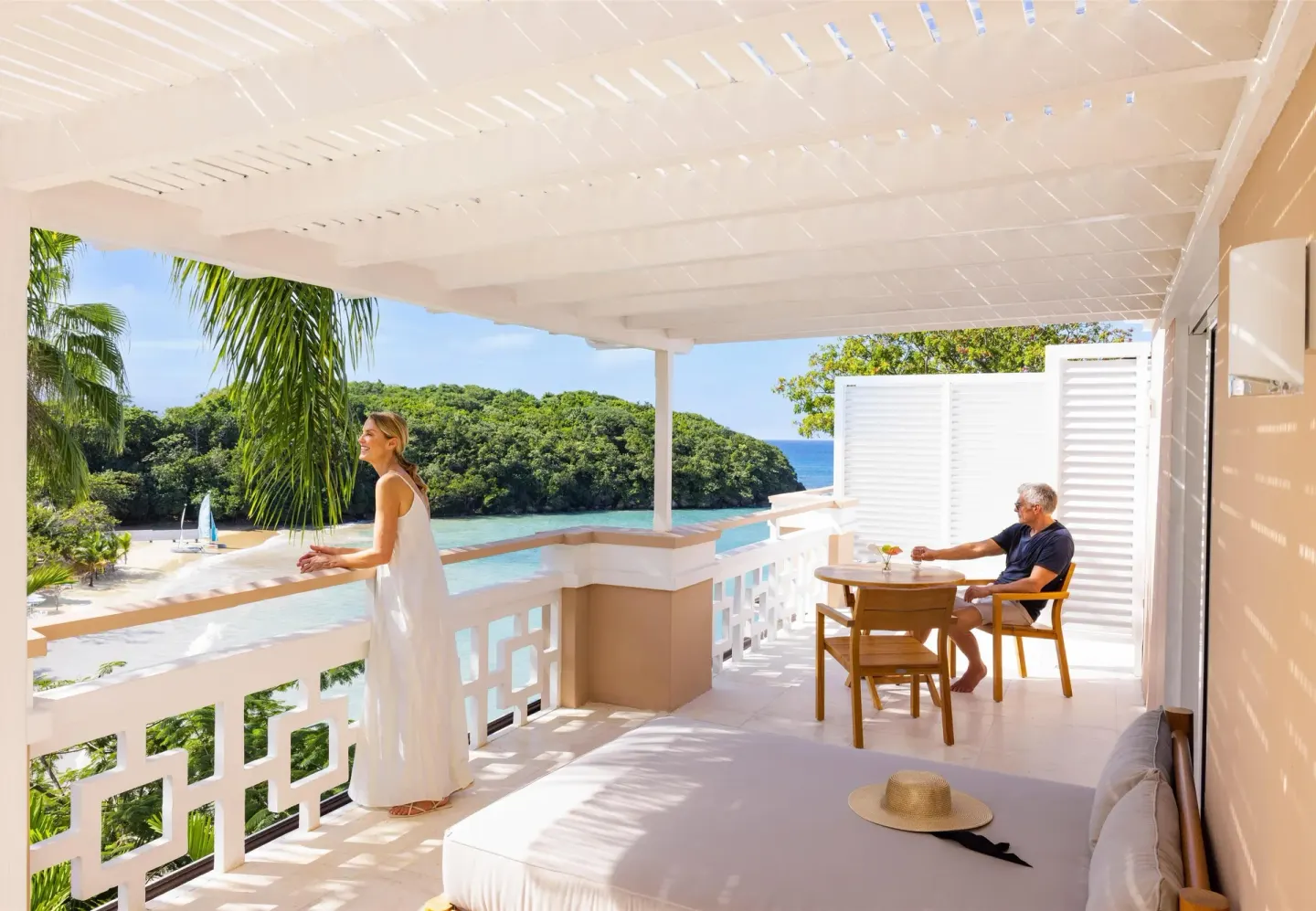 Covered balcony with lounge seating and cove views at Couples Sans Souci.