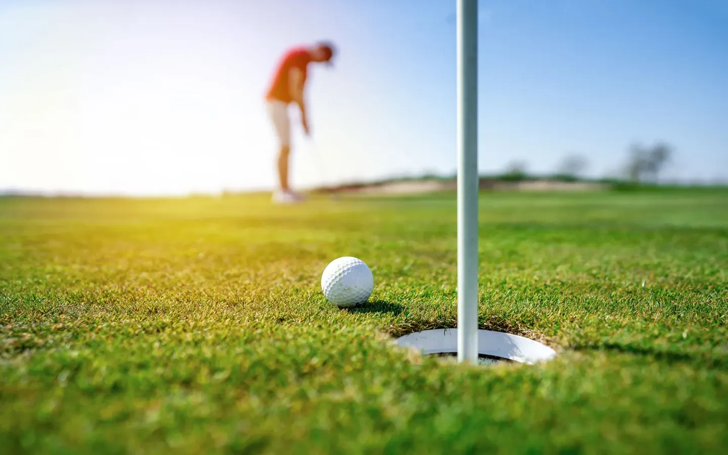 A golf ball rests near the hole on a sunny green at Couples Sans Souci.