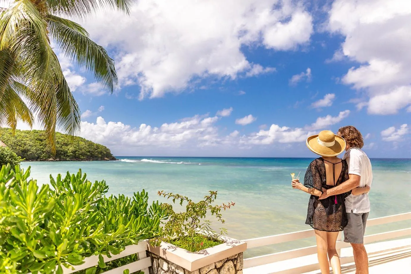 Couple looking over the turquoise bay from a terrace at Couples Sans Souci.