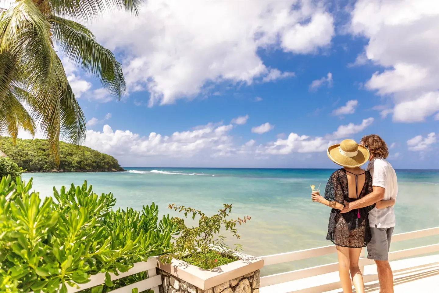 Couple overlooking the turquoise cove from a seaside terrace at Couples Sans Souci.