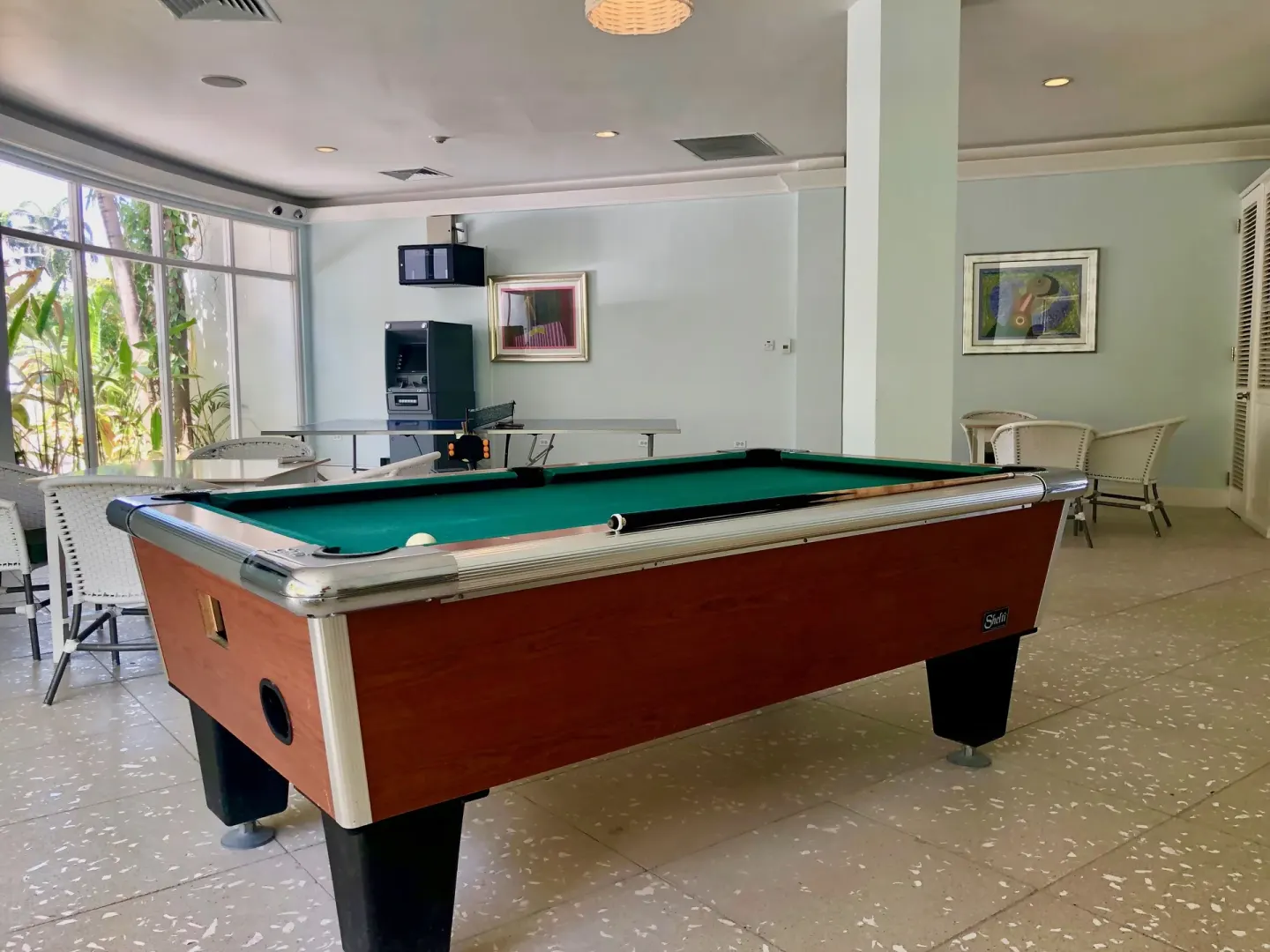 A billiards table fills a bright indoor game room at Couples Tower Isle.