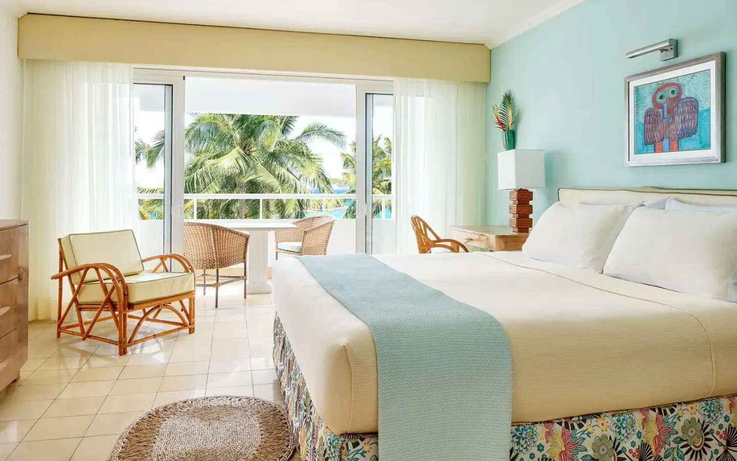 Guest room with king bed and palm-view balcony at Couples Tower Isle.