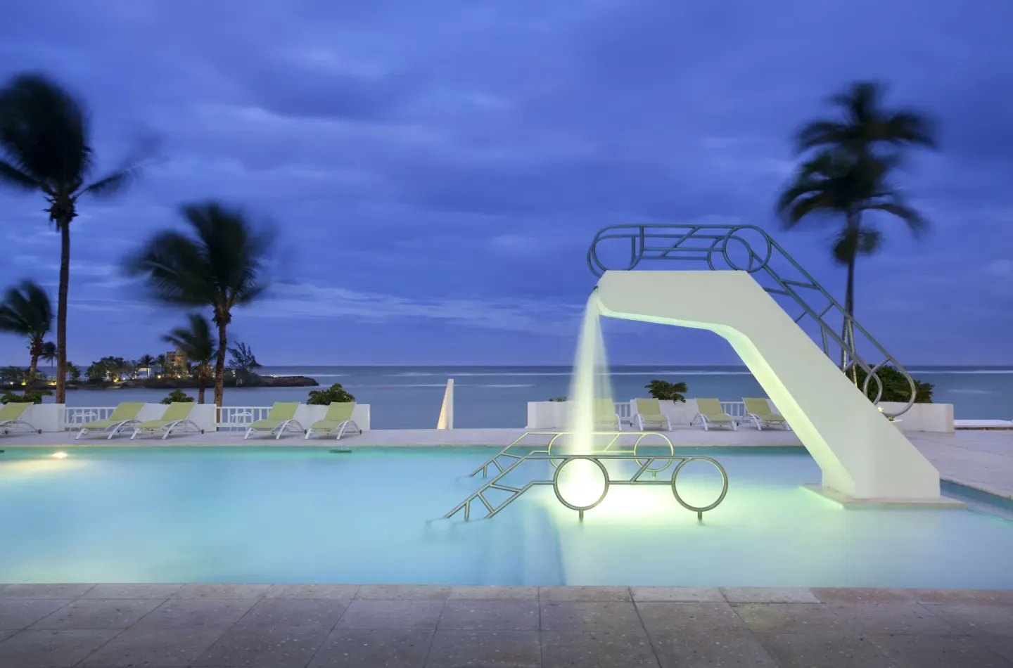Illuminated pool slide overlooking the sea at dusk at Couples Tower Isle.