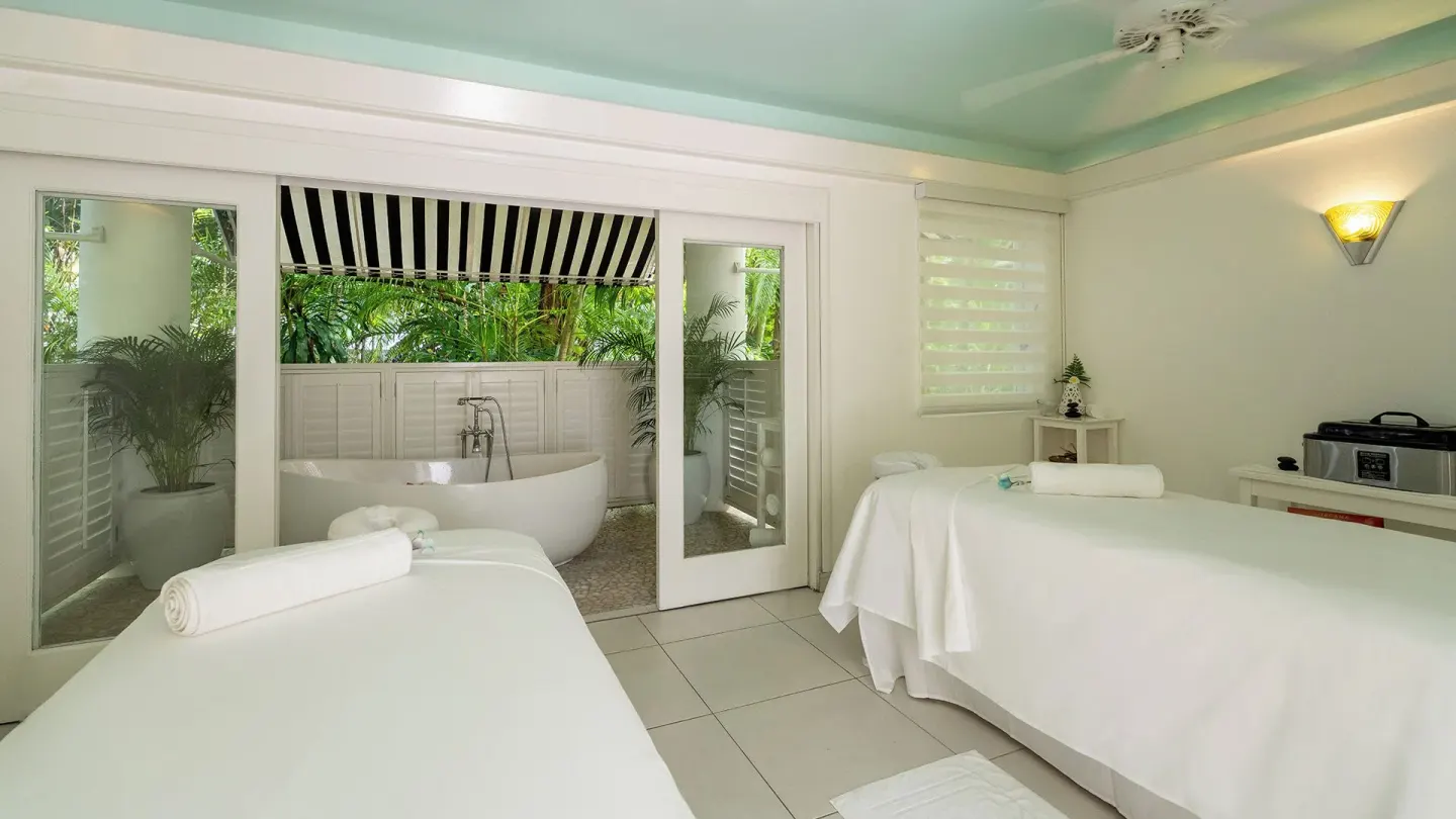 Spa treatment room with two massage tables and garden bathtub at Couples Tower Isle.