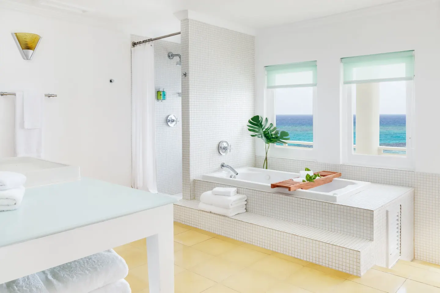 Ocean Junior Suite bathroom with soaking tub and sea-view windows at Couples Tower Isle.