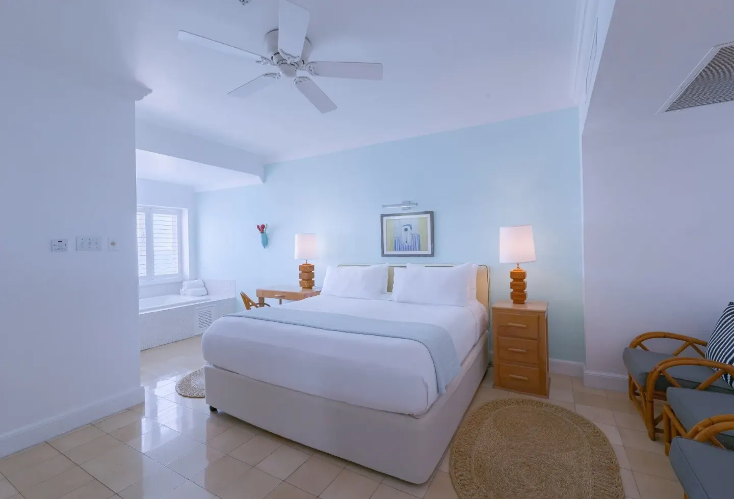 Ocean Junior Suite bedroom with king bed and sitting area at Couples Tower Isle.