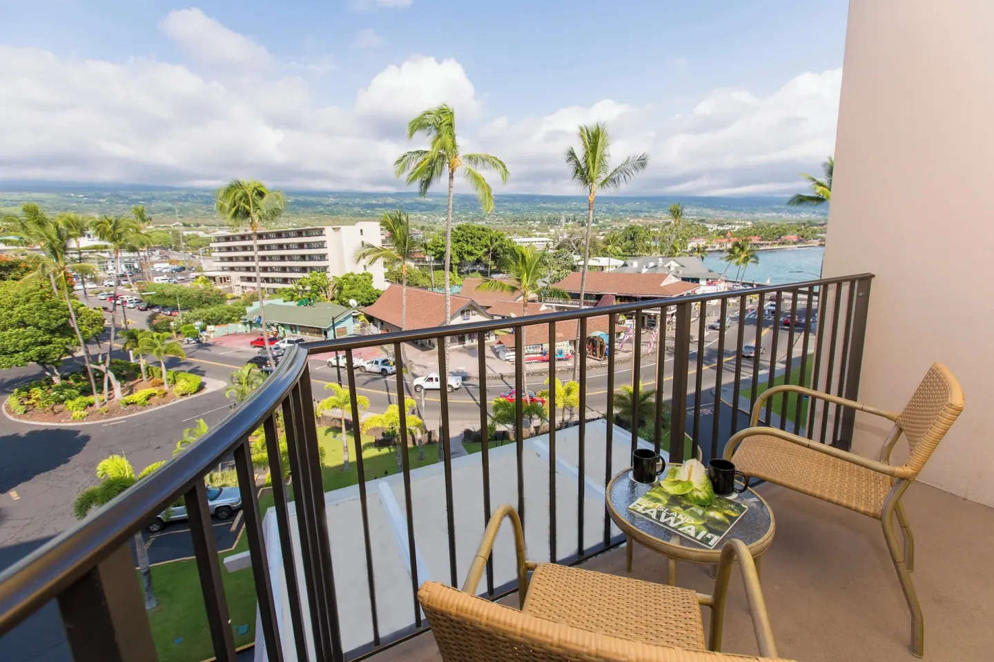 Balcony seating with town and bay view at Courtyard King Kamehameha's Kona Beach Hotel.