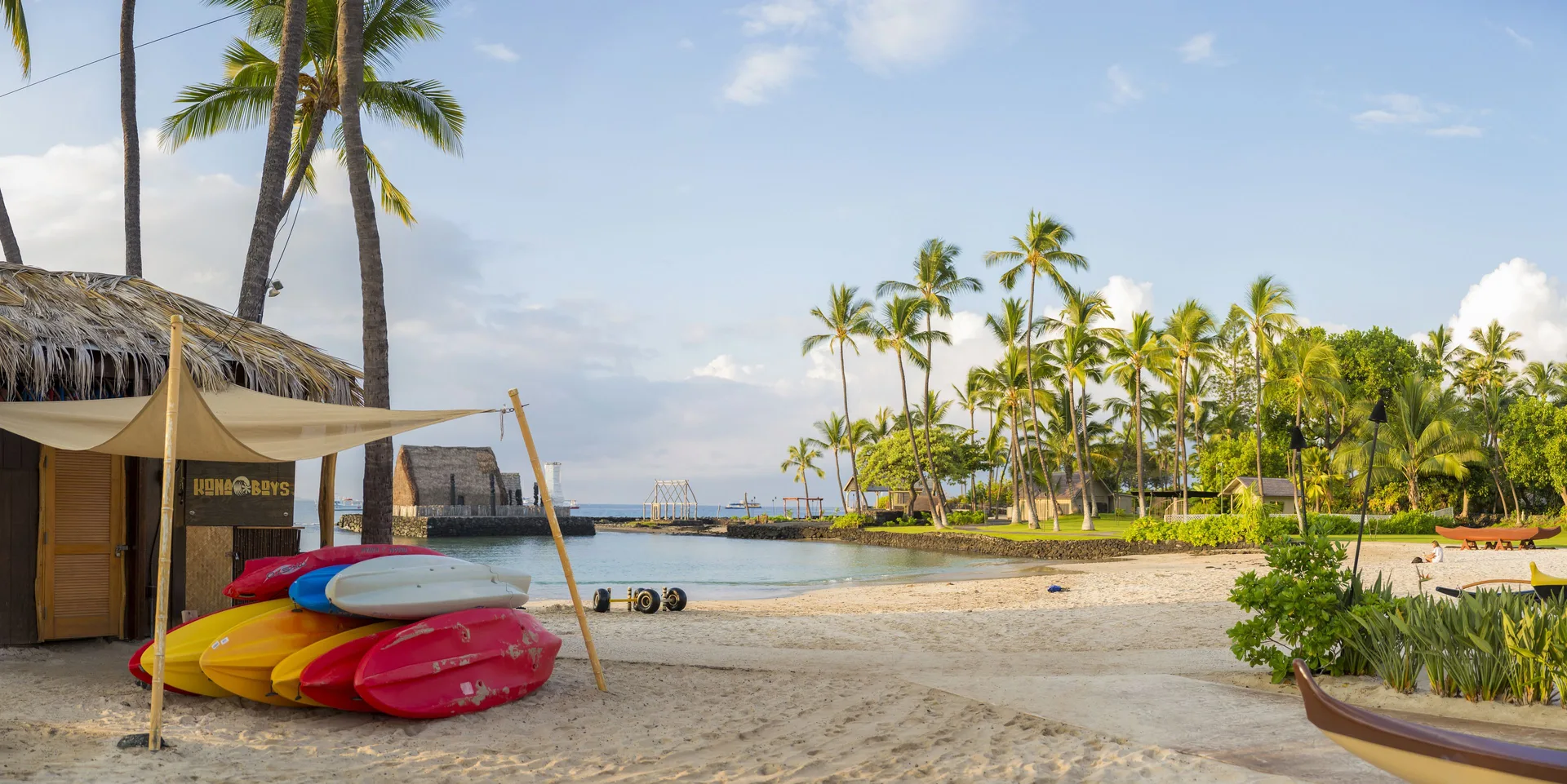 Colorful paddleboards and a sandy cove at Courtyard King Kamehameha's Kona Beach Hotel.