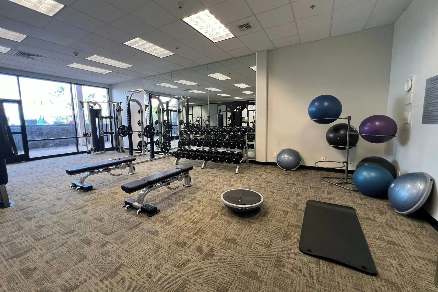 Fitness room with weights and exercise balls at Courtyard King Kamehameha's Kona Beach Hotel.