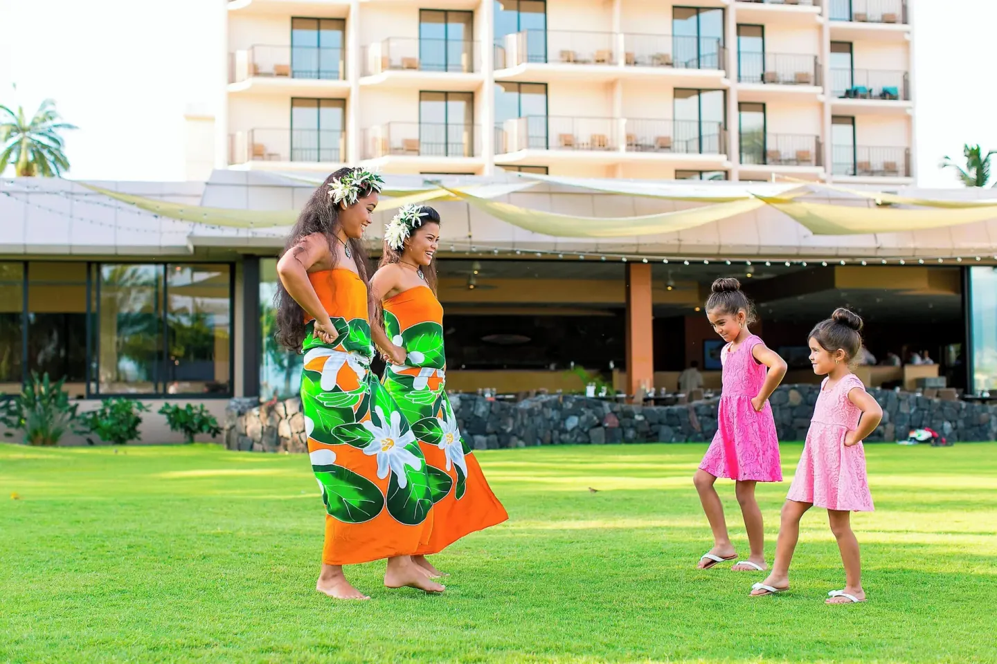 Hula dancers teaching children on the lawn at Courtyard King Kamehameha's Kona Beach Hotel.