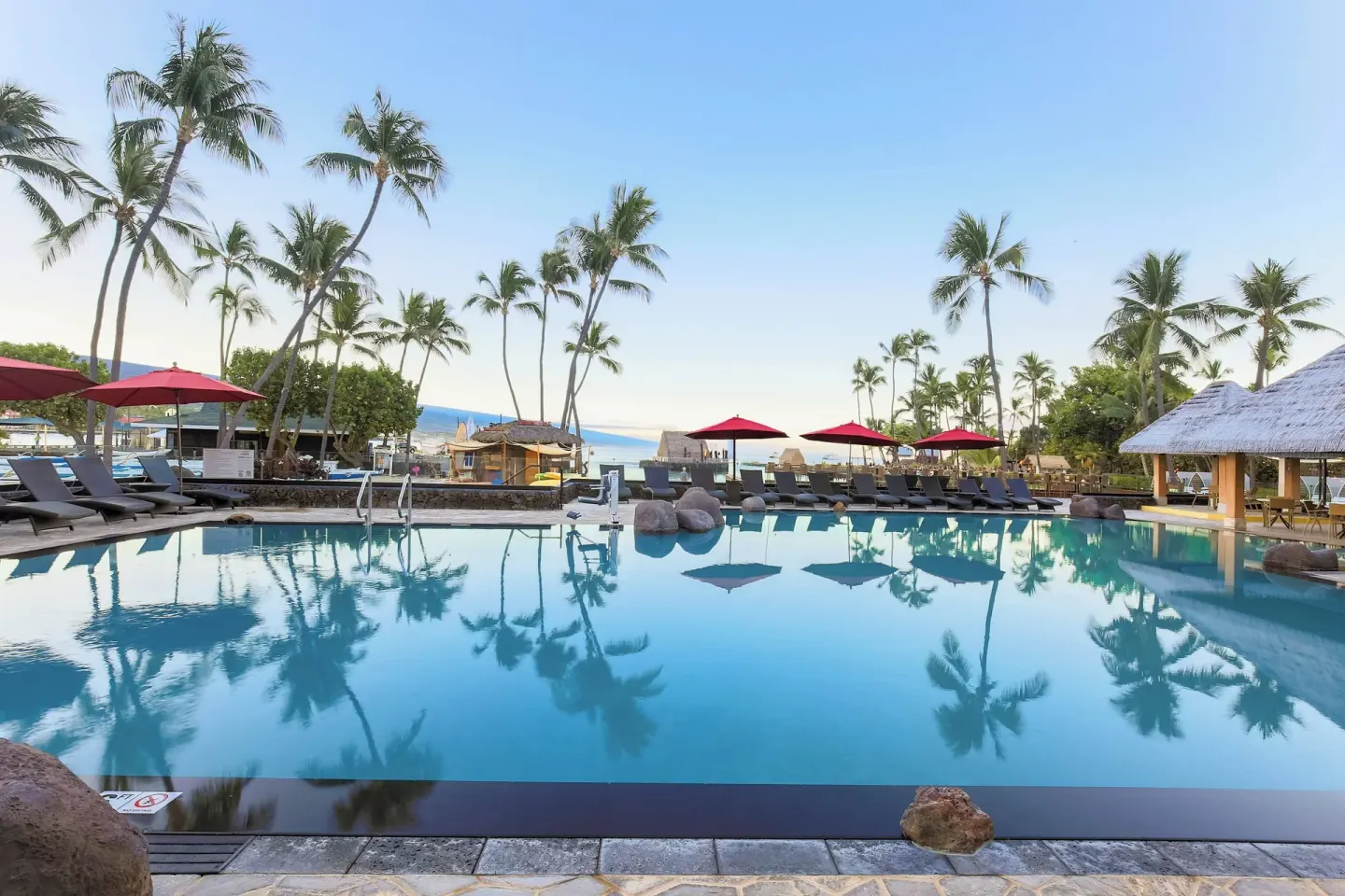 Palm-lined pool with loungers at Courtyard King Kamehameha's Kona Beach Hotel.