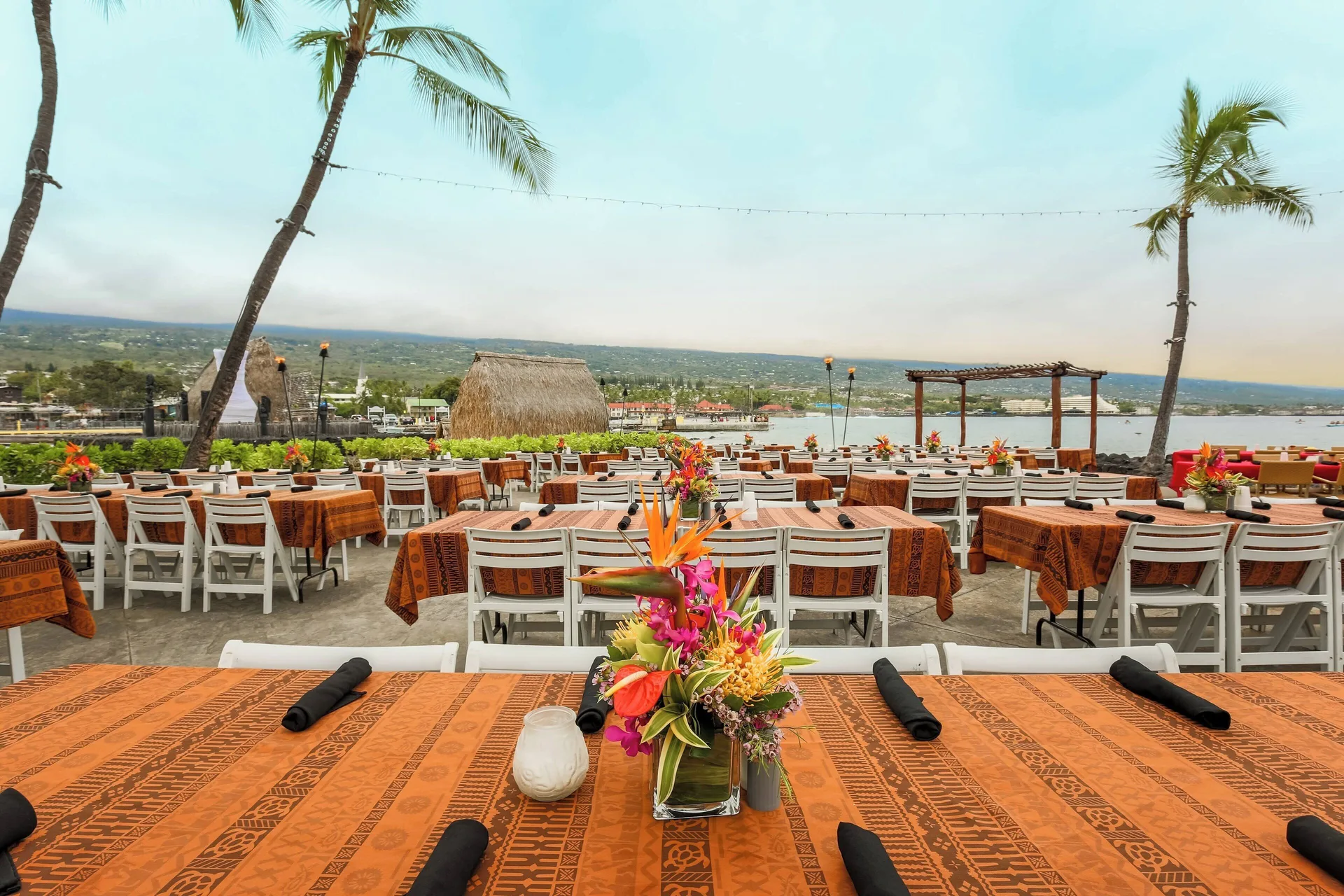 Outdoor luau tables by the bay at Courtyard King Kamehameha's Kona Beach Hotel.