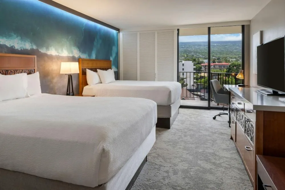 Two-bed mountain view guest room with balcony at Courtyard King Kamehameha's Kona Beach Hotel.