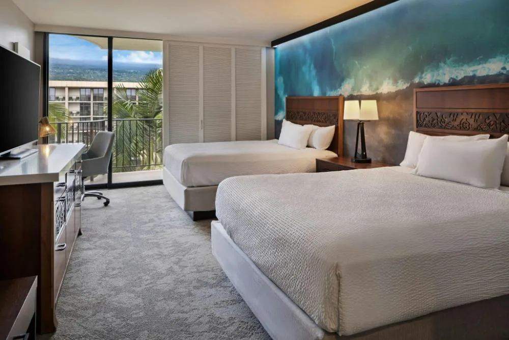 Two-bed resort view guest room with balcony at Courtyard King Kamehameha's Kona Beach Hotel.