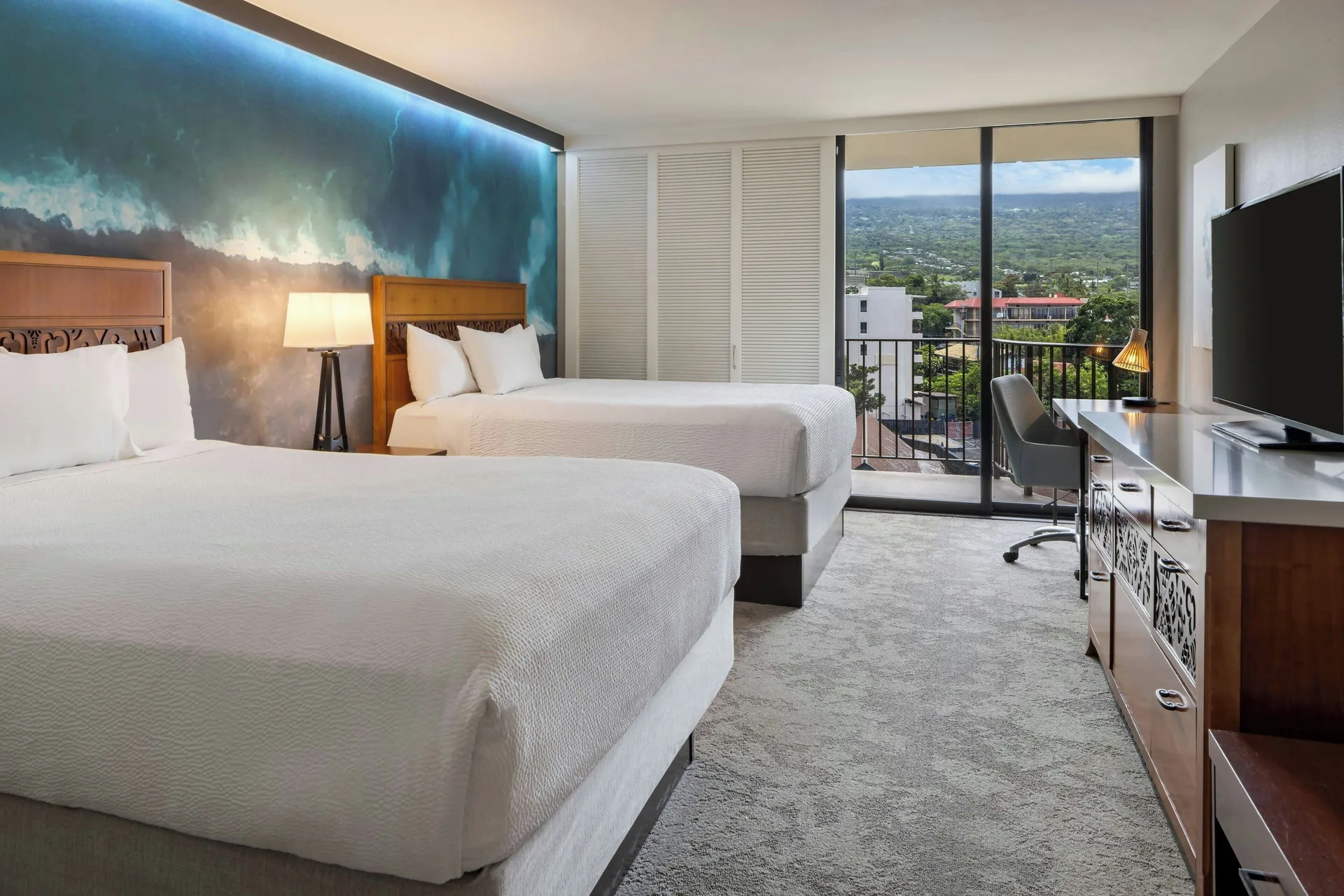 Two-bed guest room with balcony mountain view at Courtyard King Kamehameha's Kona Beach Hotel.