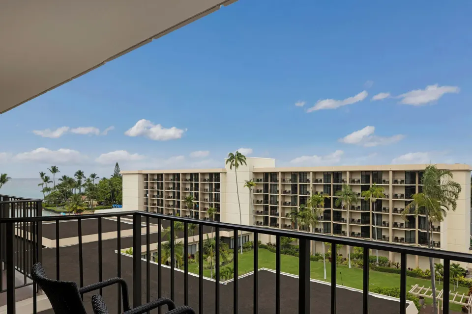 Balcony with chairs and resort buildings at Courtyard King Kamehameha's Kona Beach Hotel.