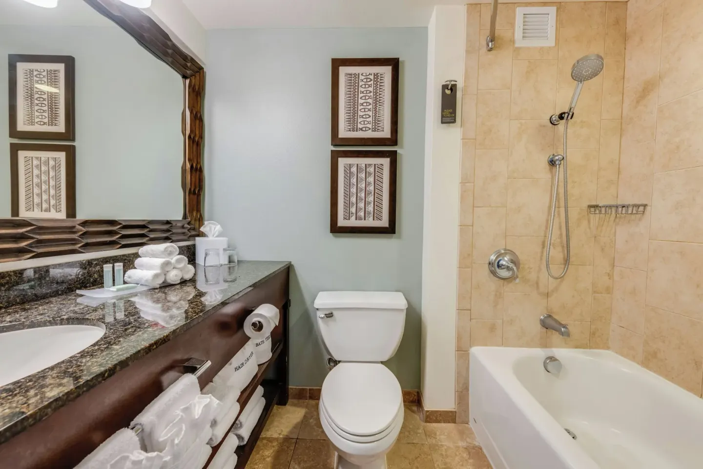 Guest bathroom vanity and tub shower at Courtyard King Kamehameha's Kona Beach Hotel.