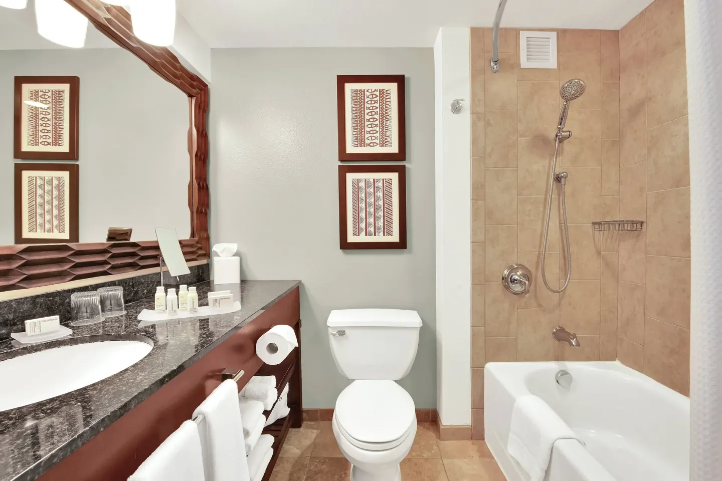 Guest bathroom with vanity and tub shower at Courtyard King Kamehameha's Kona Beach Hotel.