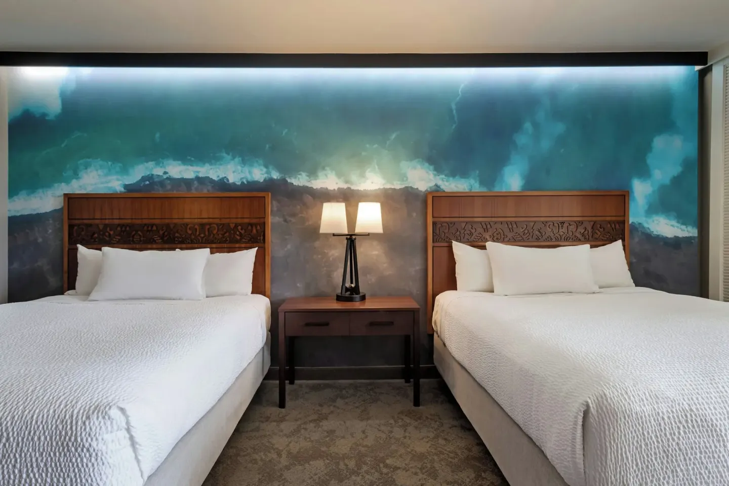 Two queen beds and bedside table at Courtyard King Kamehameha's Kona Beach Hotel.