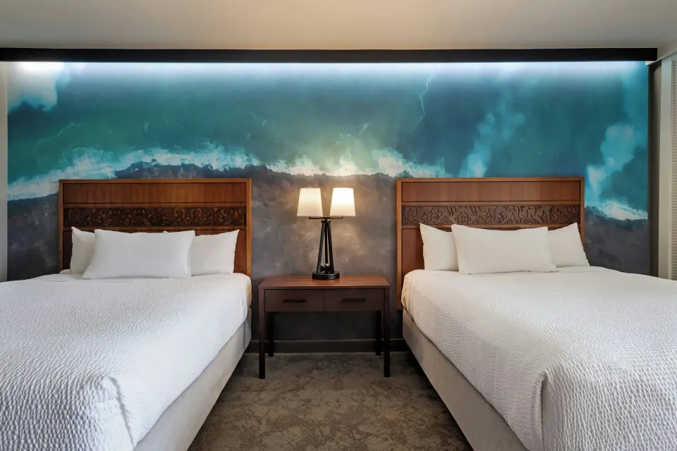 Two queen beds and bedside table at Courtyard King Kamehameha's Kona Beach Hotel.