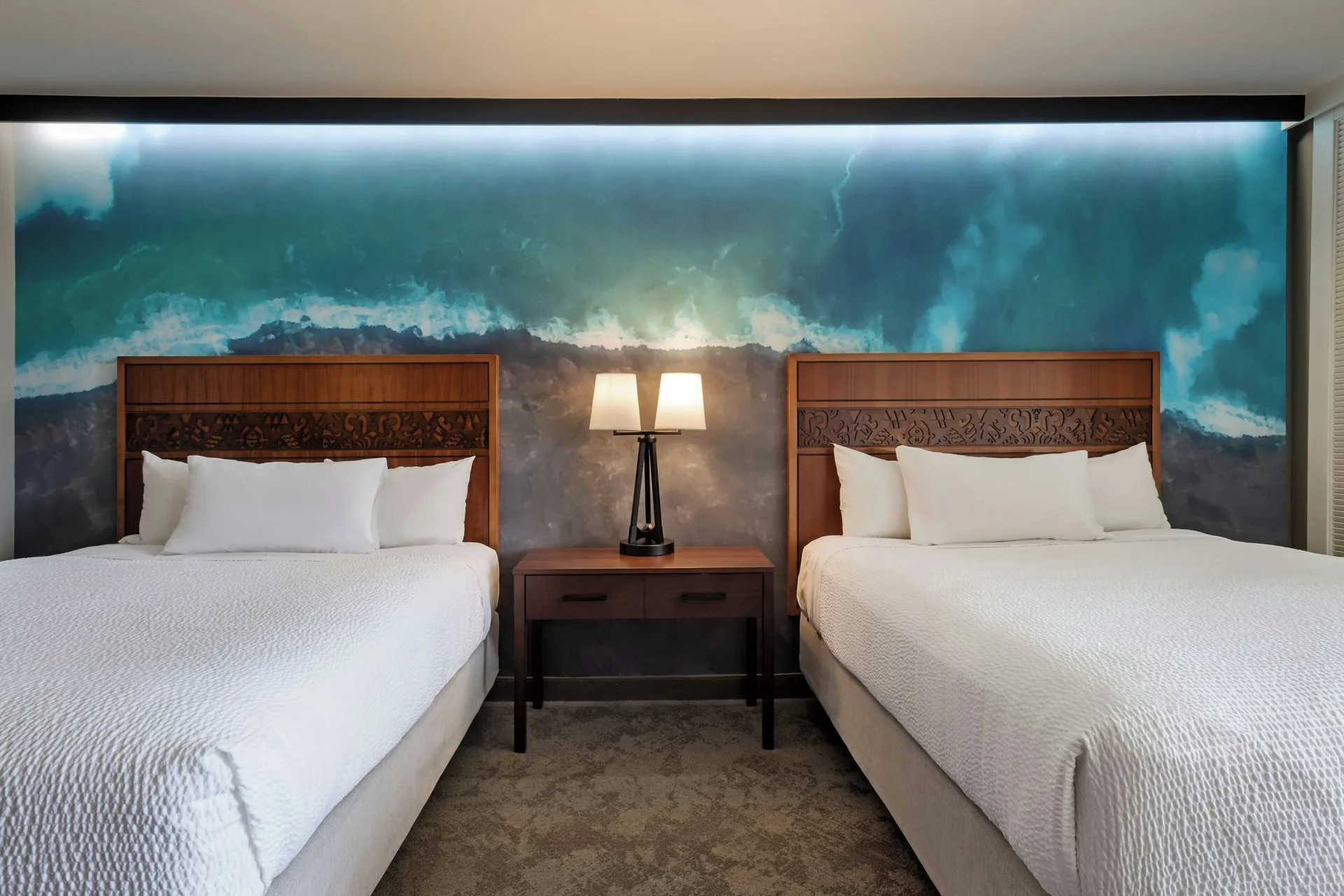 Two queen beds and bedside table at Courtyard King Kamehameha's Kona Beach Hotel.